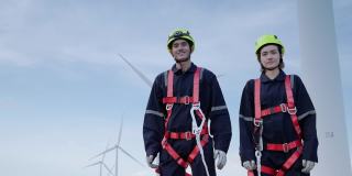 两名身穿安全装备的维修工程师站在高处，竖起大拇指，骄傲地微笑着为他们的服务，清洁能源理念，可再生能源，拯救世界。