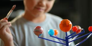亚洲男孩画太阳系模型。创造性和学习的概念