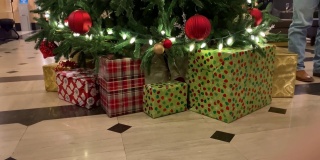 酒店大堂有一棵漂亮的圣诞树，圣诞树下挂满了包装精美的礼物，树枝上挂满了喜庆的装饰品和明亮的圣诞彩灯