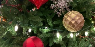 近距离观看圣诞树上色彩鲜艳的圣诞装饰品，清晰的圣诞灯和金属丝