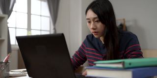 一位台湾女大学生在家里学习时，眼睛突然变得模糊，她靠在笔记本电脑屏幕前，试图看得更清楚