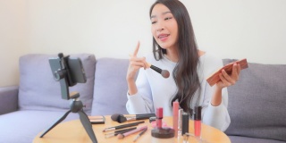 年轻的亚洲女性在网上评论化妆品