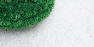 绿色的圣诞树在白色的毛皮地毯上。从右向左倾斜射击。