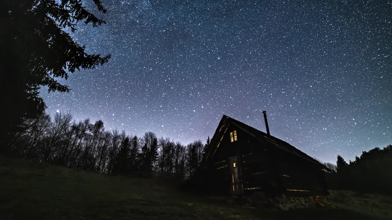 浪漫的星空与银河系快速旋转古老的木屋在野生森林的自然天文学时间推移4k