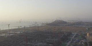 日落时分，一座大型城市建筑群的施工现场，天空中浪漫的彩云