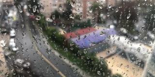雨天，雨点落在街景的窗玻璃上。