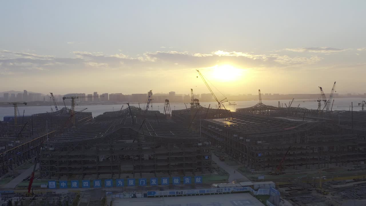 日落时分，一座大型城市建筑群的施工现场，天空中浪漫的彩云