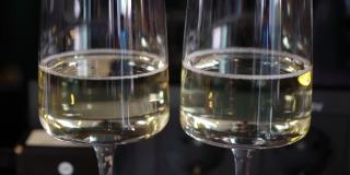 两个葡萄酒杯，配上起泡的白色香槟，酒精饮料