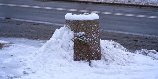 城市街道混凝土公共垃圾箱被大雪覆盖的垃圾箱在强烈的冬季降雪暴风雪
