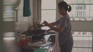 在平底锅里做饭的亚洲高级妇女。视频素材模板下载