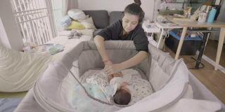 亚洲妈妈准备给小宝宝(0-1个月)换尿布。