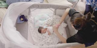 亚洲妈妈准备给小宝宝(0-1个月)换尿布。