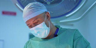 男性外科医生在诊所工作的肖像。戴医用口罩的医生正在做抽脂手术。专业医生做手术。