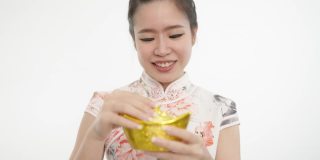 中国妇女在农历新年拿着代表财富的金条。