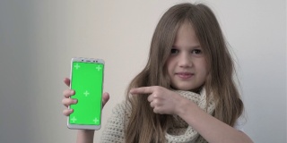 小女孩咳嗽打喷嚏，并显示手机与绿色屏幕模拟。绿屏智能手机的色度键设置为广告。医生，诊所，药房，送药，药物，接种疫苗