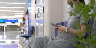快乐的孕妇在机场用手机