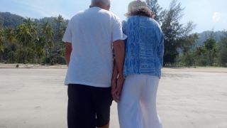 亚洲老年夫妇一起散步在海边的背景周末假期。老年人快乐生活的概念。视频素材模板下载