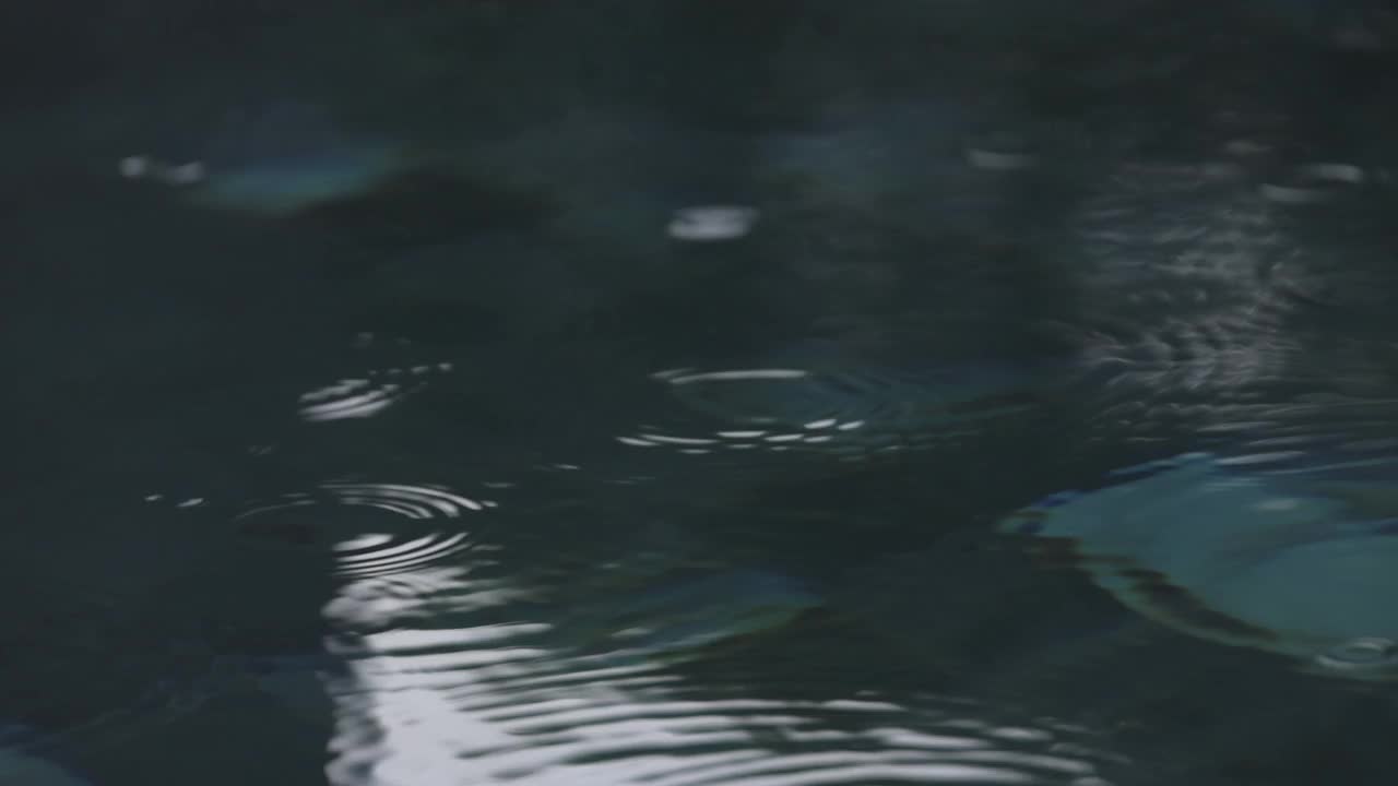 4K慢动作视频特写水池中的雨滴。