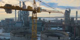 日落时分，工业生产区的水泥厂鸟瞰图，厂房结构高大，塔式起重机。