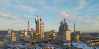 日落时分，工业生产区的水泥厂鸟瞰图，厂房结构高大，塔式起重机。
