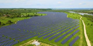 大型可持续发电厂鸟瞰图，有许多排太阳能光伏板，用于生产清洁的生态电能。零排放的可再生电力