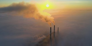 鸟瞰图，在日出时，煤电厂的高管与黑烟向上移动污染的大气。