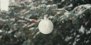 雪中的圣诞树枝上的白色球