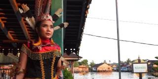 年轻女子Dayak站在河边享受