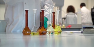 多利拍摄科学家用液体填充试管，实验室环境