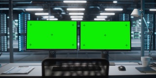 高技术数据中心服务器，两个绿色屏幕的色度键显示在个人电脑上，站在桌子上。现代监控网络服务概念、云计算、网络安全
