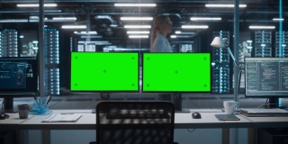 高技术数据中心服务器，两个绿色屏幕的色度键显示在个人电脑上，站在桌子上。现代监控网络服务概念、云计算、网络安全