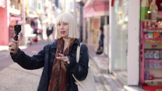 一个戴着白金金色假发的年轻女子走在购物街拍视频视频素材模板下载