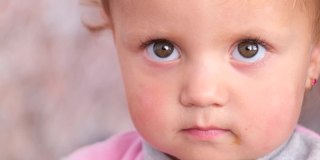 一个可爱的悲伤的婴儿与大眼睛的特写肖像。
