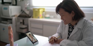 医生在一个远程医疗视频电话与老年患者使用移动电话在医疗诊所