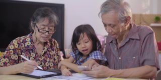 亚洲老夫妇教孙子在家里做个人理财