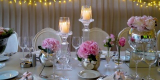 时尚干净的婚礼装饰，粉红色的花朵和烛光