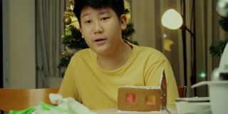 亚洲男孩和妹妹在晚上在家做姜饼屋，圣诞节庆祝生活方式的概念。
