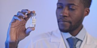非洲裔美国医生手持Covid-19疫苗瓶