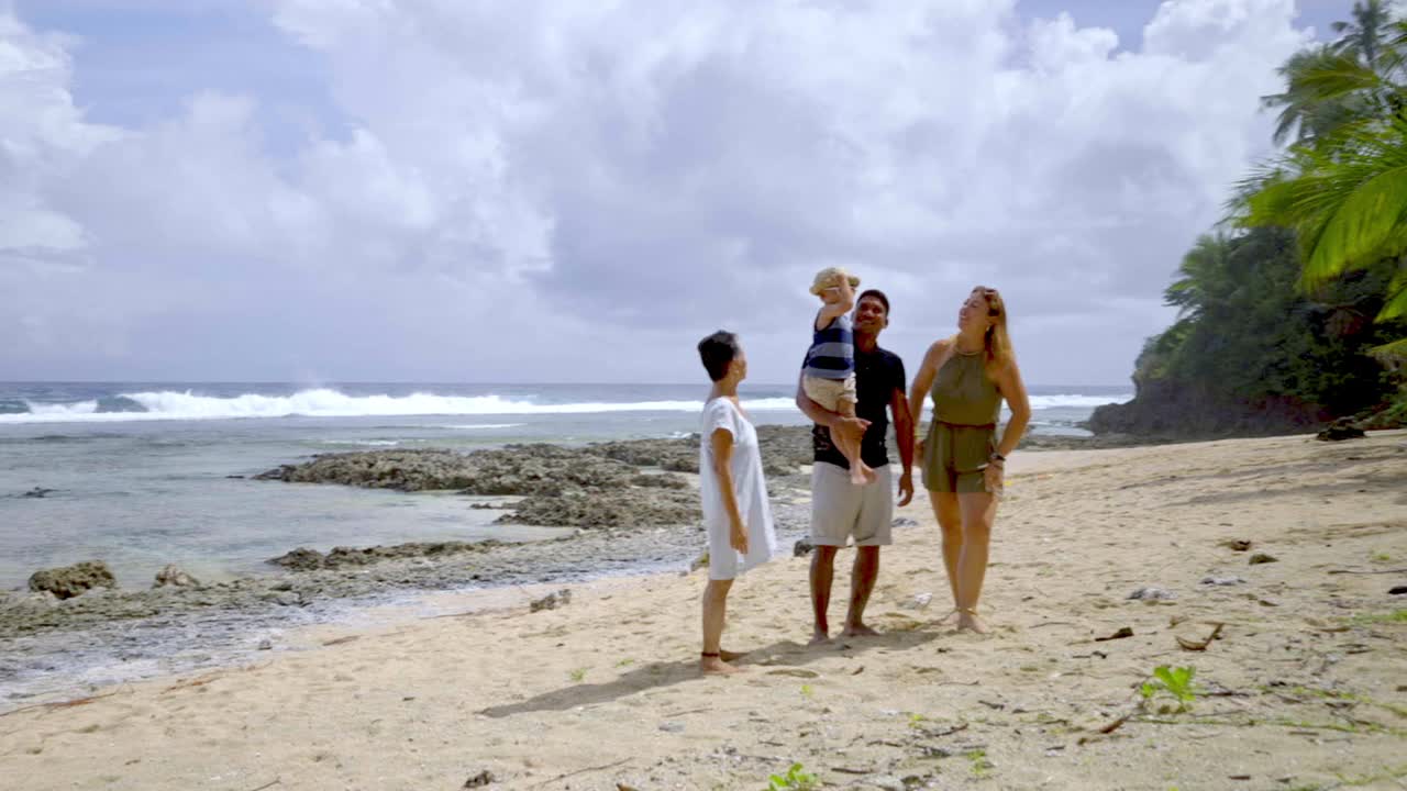 几代人的家庭在海滩上享受时光