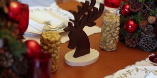空空如也的圣诞餐桌的特写视频，疫情期间空空如也的圣诞餐桌上的慢动作视频，圣诞主题的餐桌，圣诞装饰蜡烛和餐桌上的木鹿，