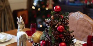 空空如也的圣诞餐桌特写视频，疫情期间空空如也的圣诞餐桌上的慢动作视频，圣诞主题的餐桌，圣诞装饰的圣诞树，餐桌上的木鹿。
