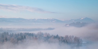 美丽的冬季风景，时光流逝。自然界的冬季雾。天气恶劣，气温寒冷。山上和森林上有雪。意大利阿尔卑斯山,Belluno。