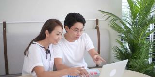 兴奋的亚洲夫妇使用笔记本电脑，获奖者