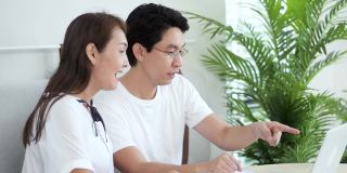 慢动作激动的亚洲夫妇使用笔记本电脑，获奖者