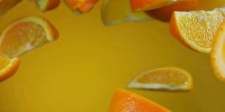 多汁美味的熟透的橘子片在黄色的背景上跳跃
