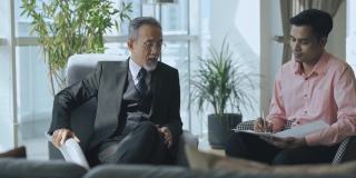 成功的亚洲华人CEO在办公室与他的秘书和私人助理谈话
