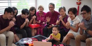 春节期间，亚洲华人通过笔记本电脑在客厅进行多代家庭视频会议