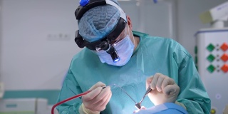 由专家进行鼻腔手术。助手和外科医生正在做鼻子手术。医生在手术中使用医疗器械。特写镜头。