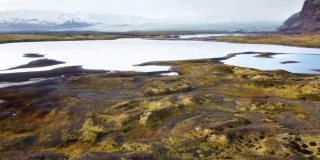 神奇的空中飞行在冰岛上空，从鸟瞰，这里是一片有着绿色苔藓和蓝绿色湖泊的火山景观。美丽而原始的自然