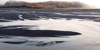 鸟瞰图，冰岛河流流入海洋的图案，不同寻常的美丽景观，冰岛的早春，干净的水和原始的自然